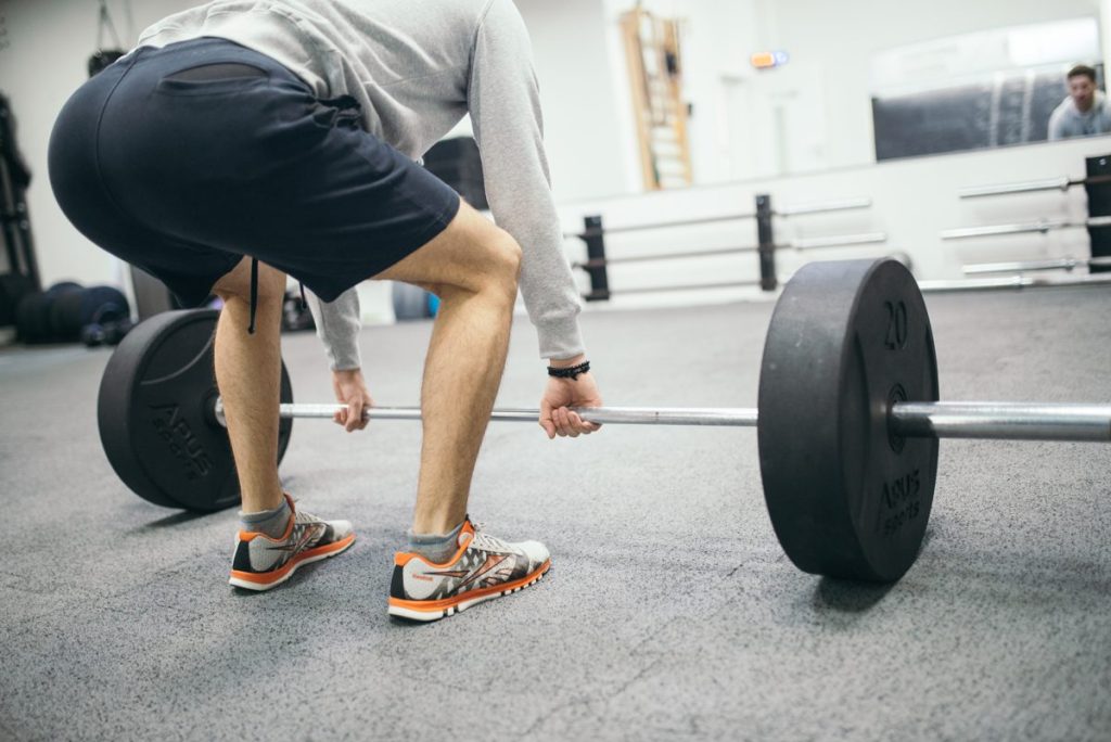 Athlète soulevant une barre chargée en salle de musculation